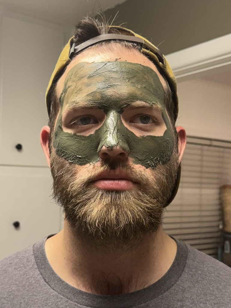 Gator Mud clay mask fully applied — deep green, beginning to crack